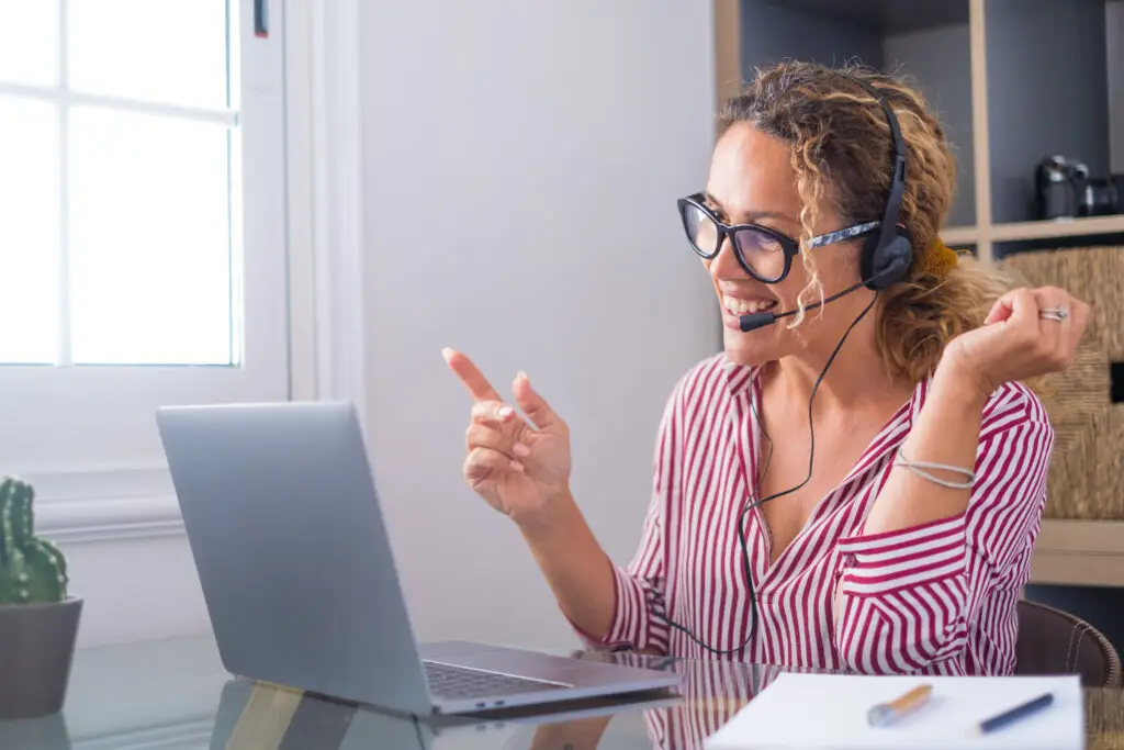 Attractive caucasian woman working as a virtual tour guide for Norway Private Tours, engaging with clients from her home office