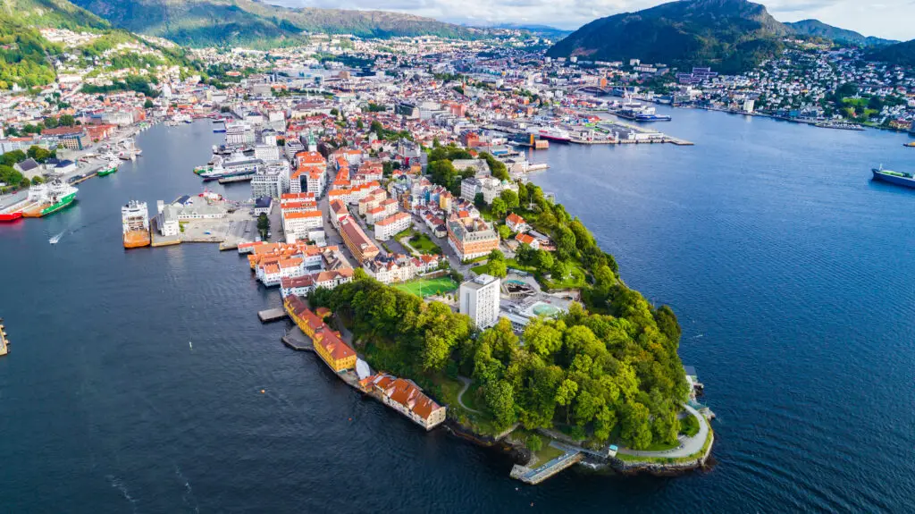 Aerial view of Bergen old town with historical buildings and scenic coastline, highlighting popular tourist destinations in Bergen, Norway.