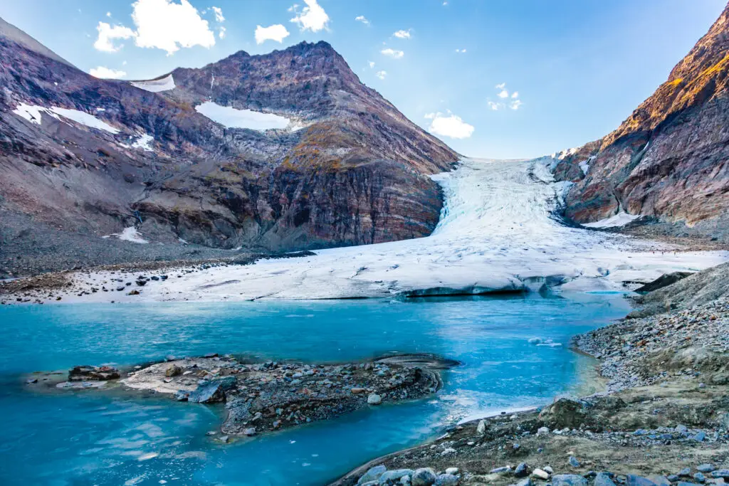 Steindalsbreen Glacier in North Norway, showing a vibrant blue glacier ice amidst rocky terrain in the Lyngen Alps near Tromso, a stunning Scandinavian tourist attraction.