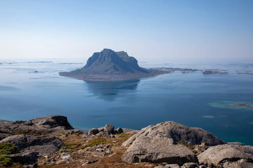 Breathtaking view of the island of Vega in Norway, showcasing its unique mountainous landscape surrounded by the calm blue sea, ideal for eco-tourism and nature enthusiasts.