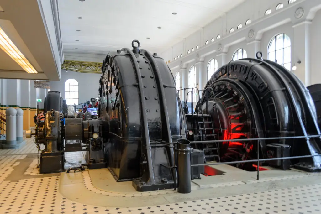 Interior view of the historical Vemork hydro power plant in Rjukan, Norway, showcasing large, old turbines and industrial equipment.